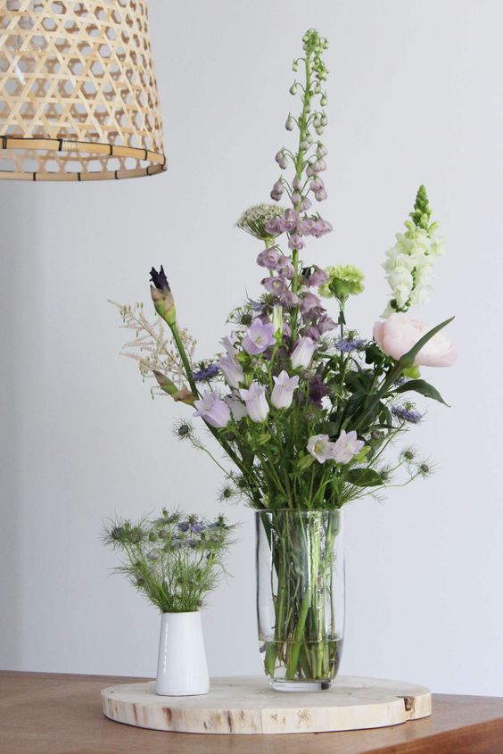 Gezelligheid in huis! Een prachtig zomer boeket met veldbloemen op een boomstammetje met een klein vaasje ernaast. Gezelligheid in huis!